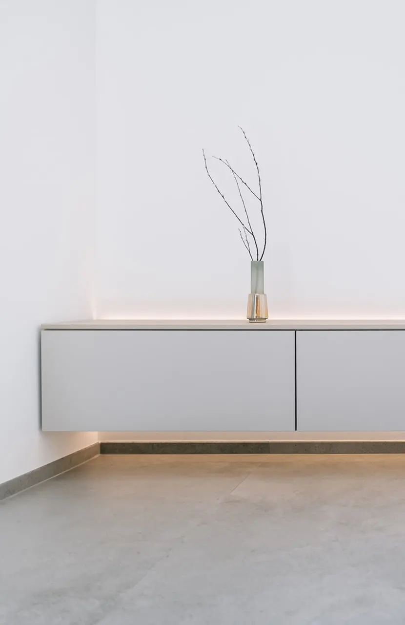 minimal cupboard against wall with vase on top